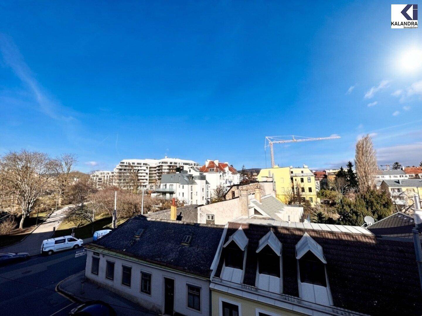 Weitläufiger Blick über die Stadt mit umliegenden Gebäuden und blauem Himmel.