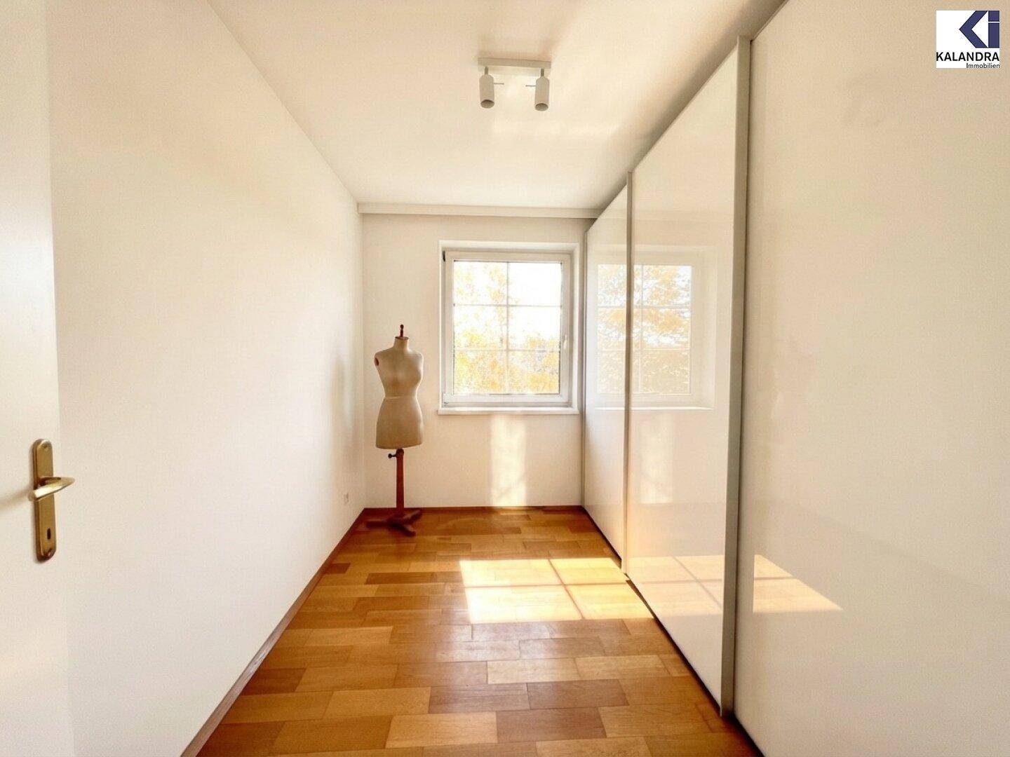 Helles Zimmer mit Parkettboden und Einbauschränken, nutzbar als Schlaf- oder Ankleidezimmer.