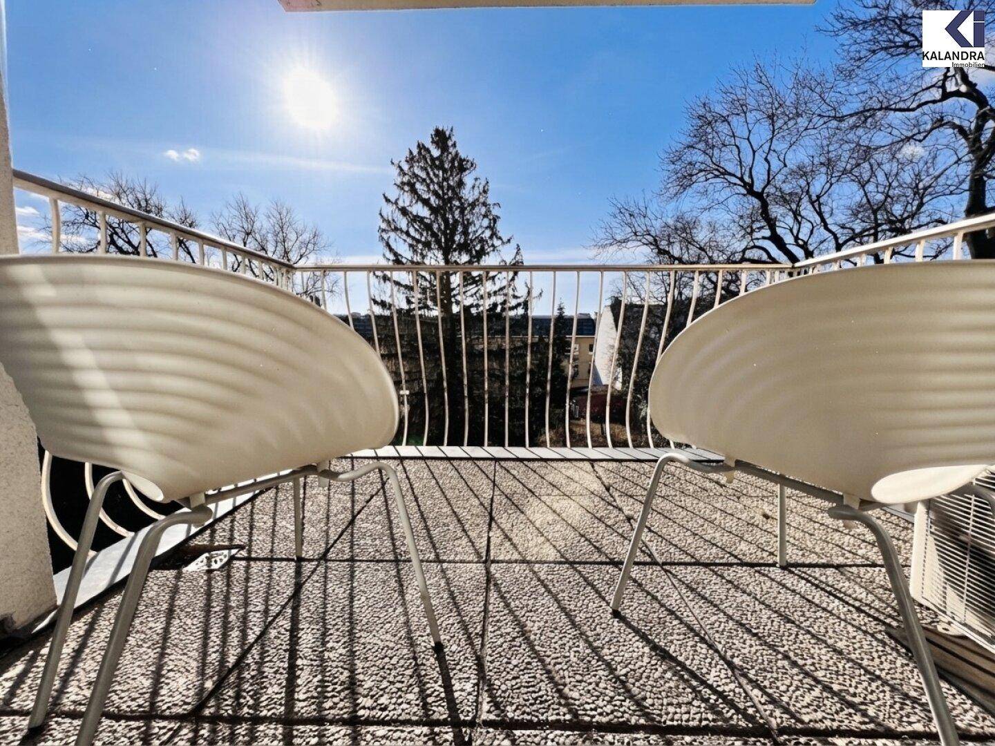 Sonniger Balkon mit Fliesenboden und zwei Stühlen, ideal für entspannte Stunden im Freien.