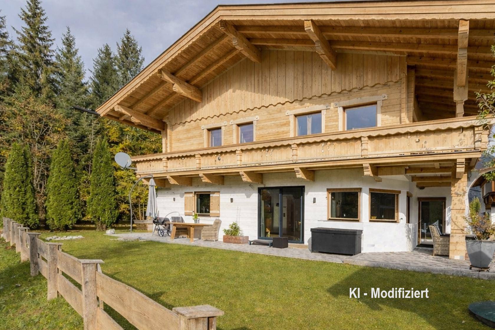 Traditionelles Holzhaus mit weißer Fassade, Balkon und gepflegtem Gartenbereich umgeben von Bäumen.