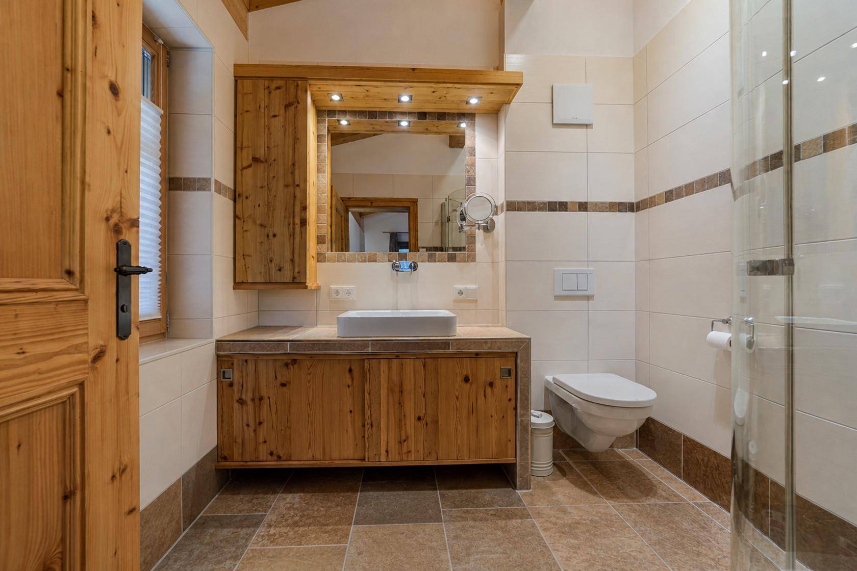 Modernes Badezimmer mit Holzwaschtisch, Fliesenboden und begehbarer Dusche.