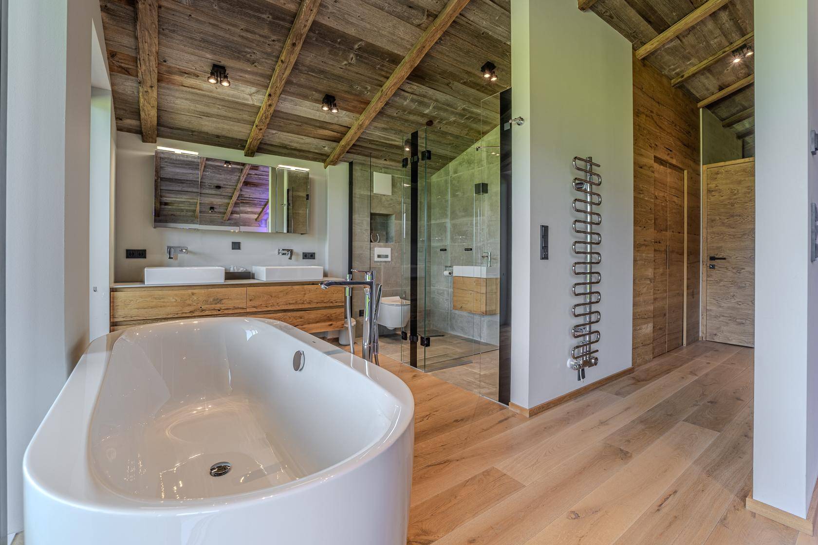 Offenes Badezimmer mit Doppelwaschbecken, begehbarer Dusche und freistehender Badewanne, modern gestaltet.