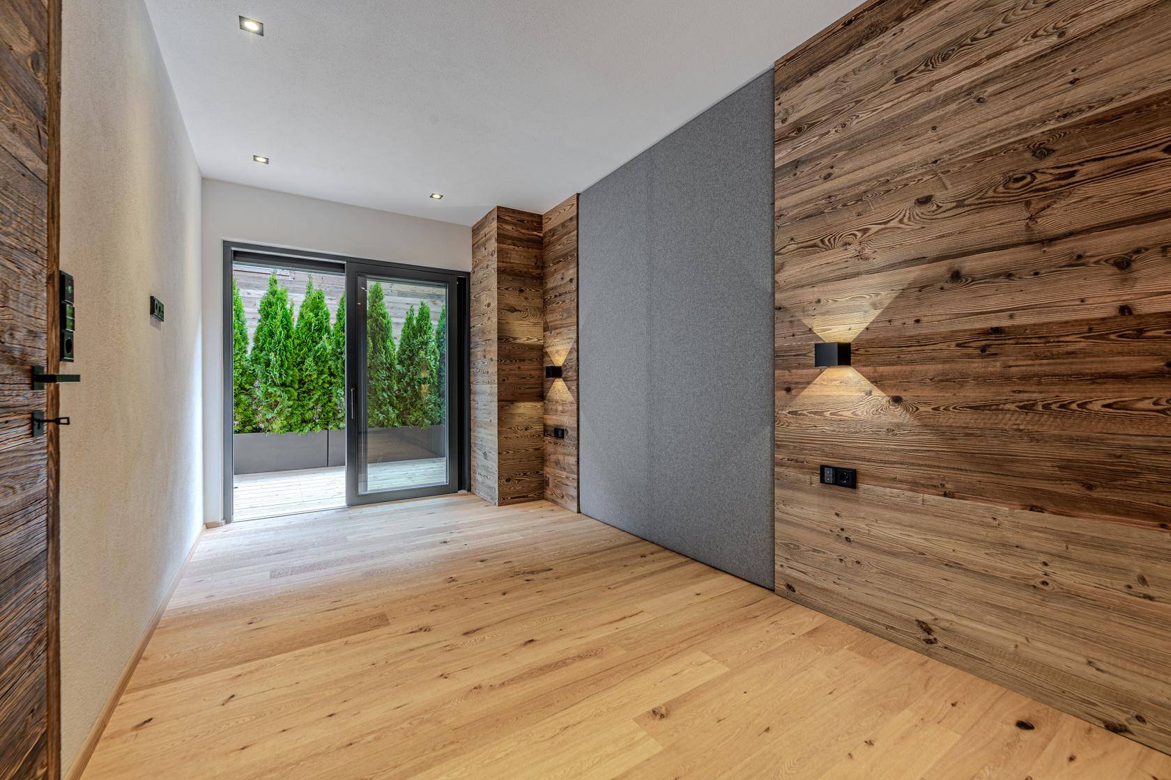 Helles Schlafzimmer mit Holzboden und Zugang zu einer privaten Terrasse.