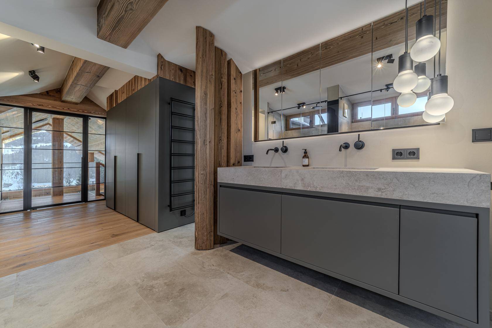 Elegantes Badezimmer mit Doppelwaschbecken, großem Spiegel und begehbarem Kleiderschrank.