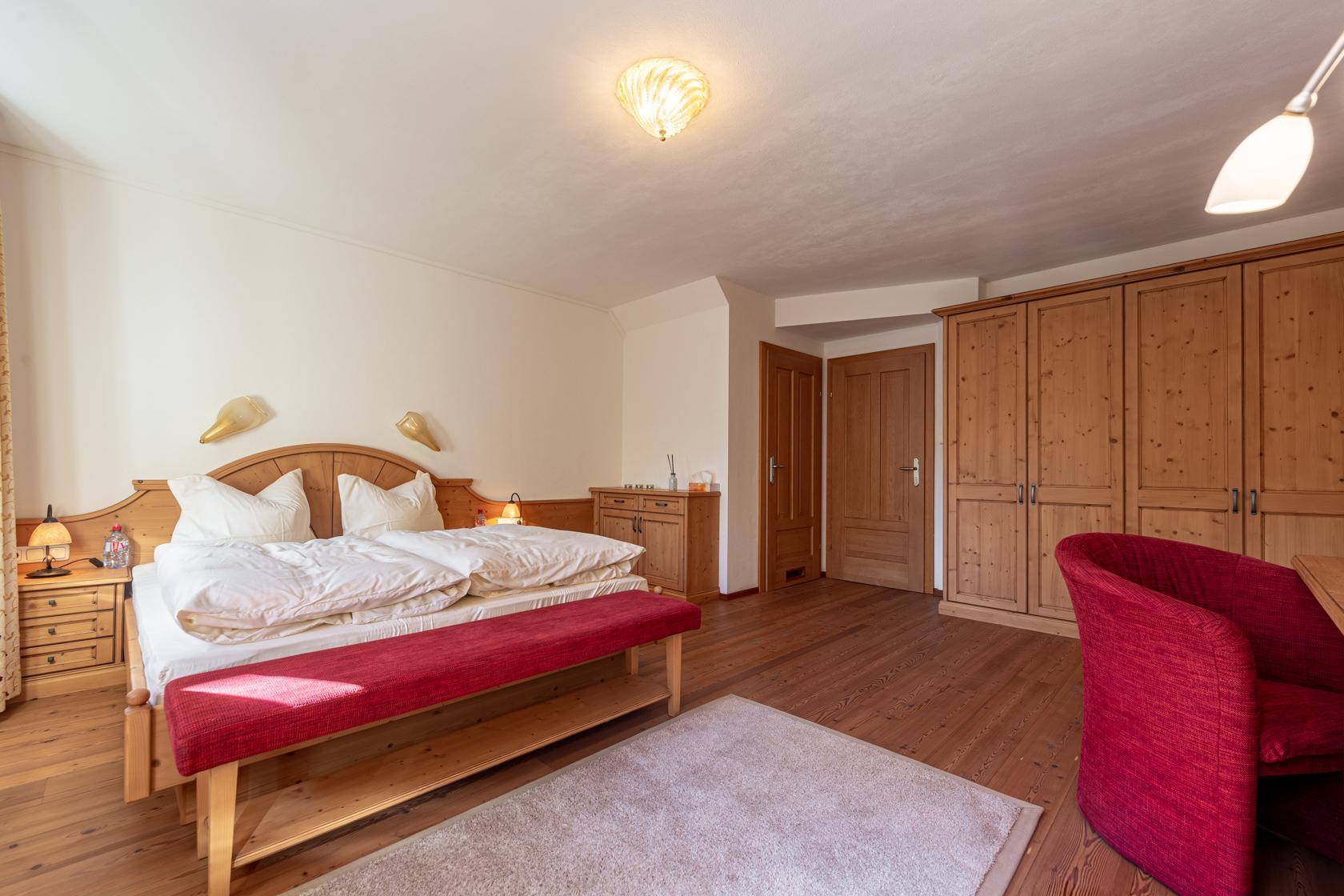 Komfortables Schlafzimmer mit Doppelbett, Holzschränken und warmem Holzboden.
