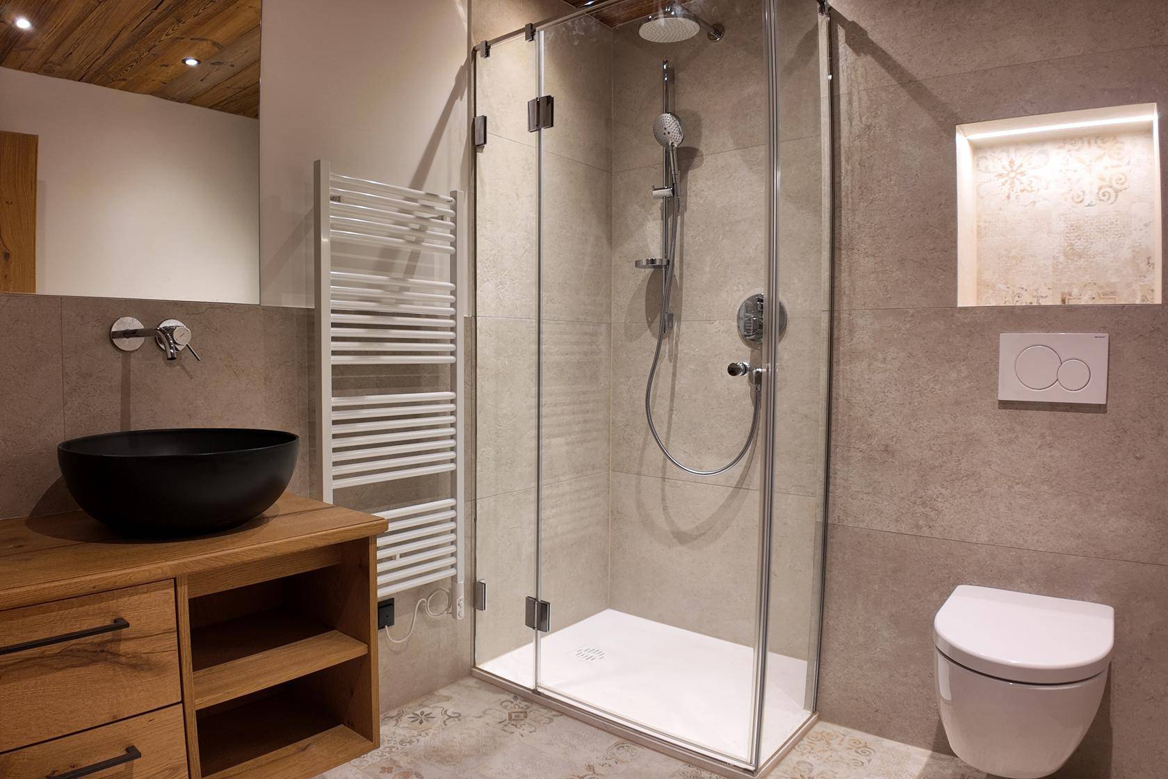 Modernes Badezimmer mit begehbarer Dusche, Waschtisch und wandhängendem WC.