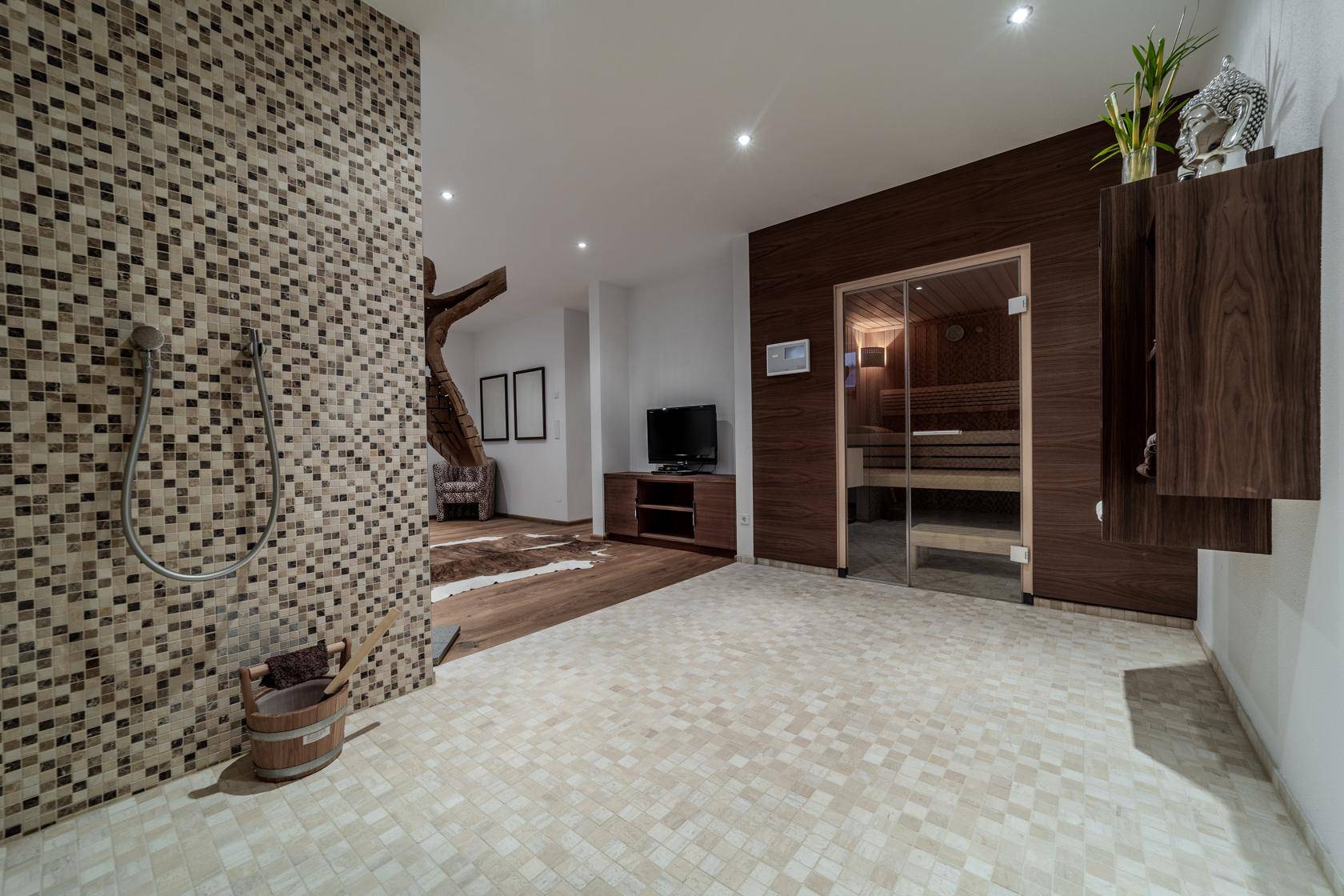 Exklusiver Wellnessbereich mit Sauna, Mosaikdusche und Entspannungszone.