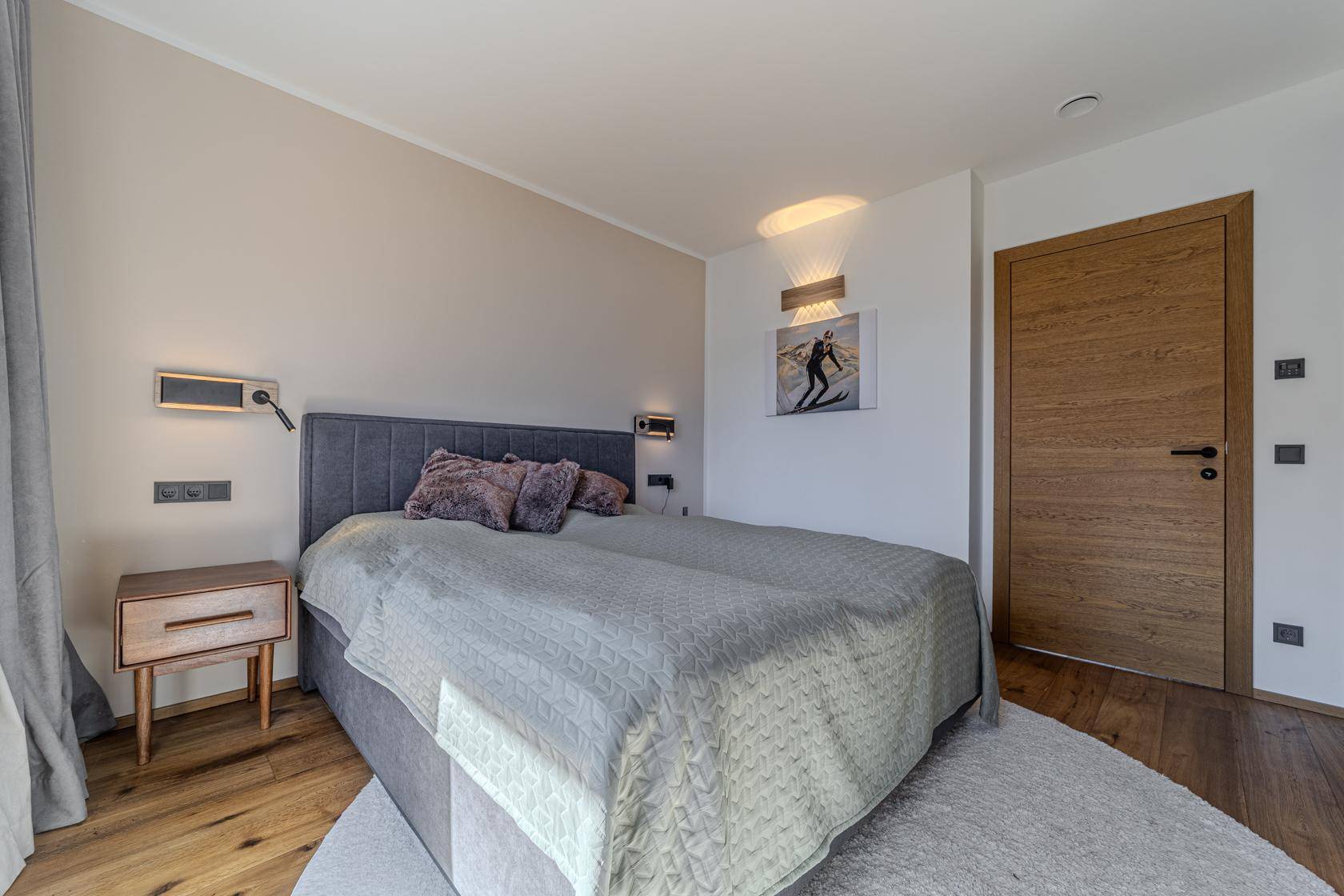 Gemütliches Schlafzimmer mit bequemem Doppelbett, Holzboden und schlichter, moderner Einrichtung.
