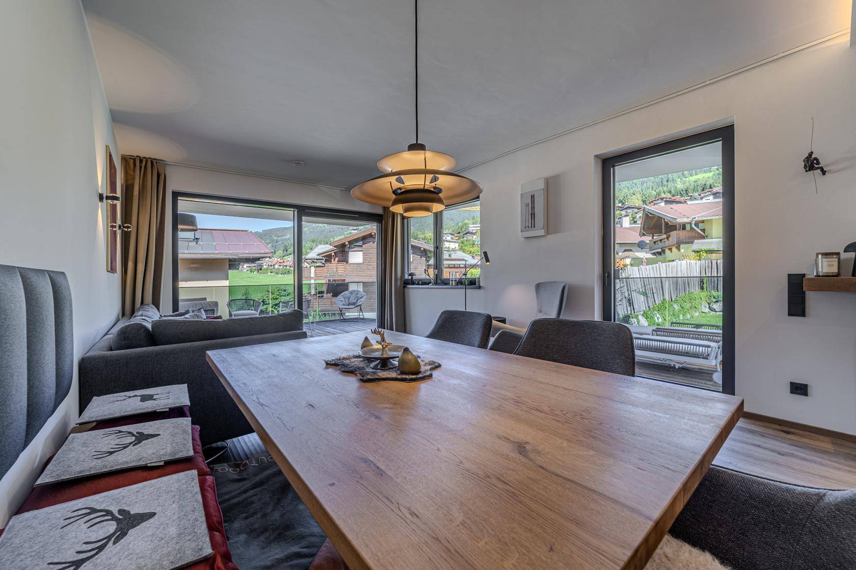 Heller Essbereich mit großem Holztisch und Panoramablick durch die bodentiefen Fenster.