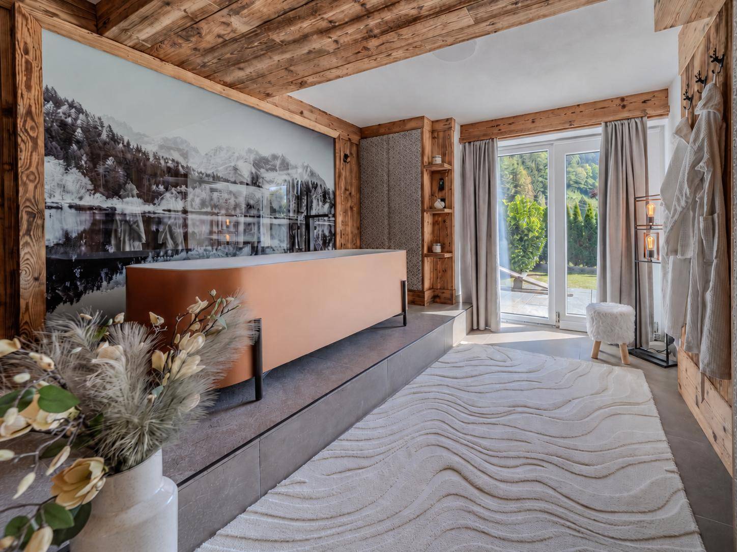 Luxuriöses Badezimmer mit freistehender Badewanne, Bergblick-Wandbild und Balkonzugang.