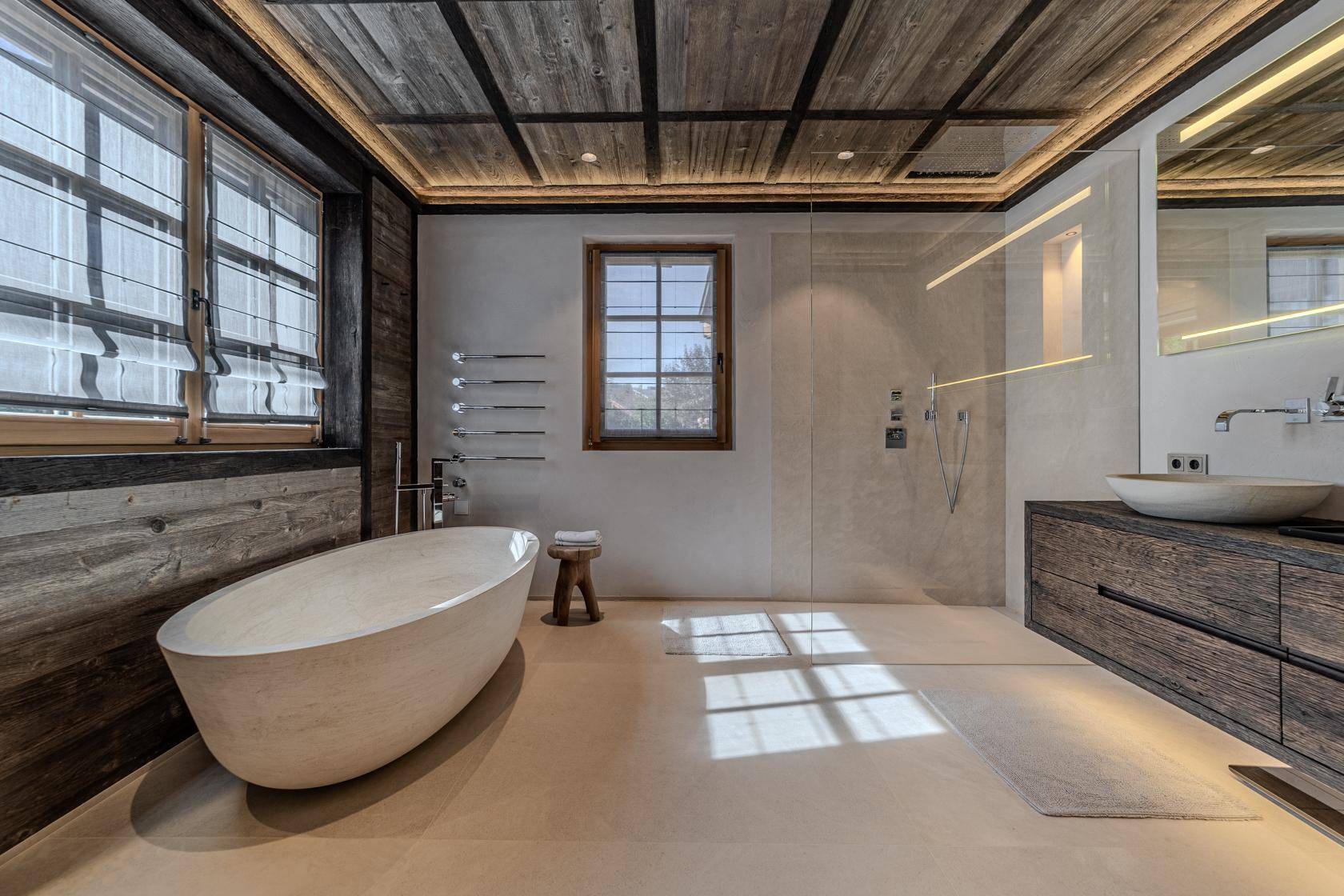 Modernes Badezimmer mit freistehender Badewanne, begehbarer Dusche und Holzwänden.