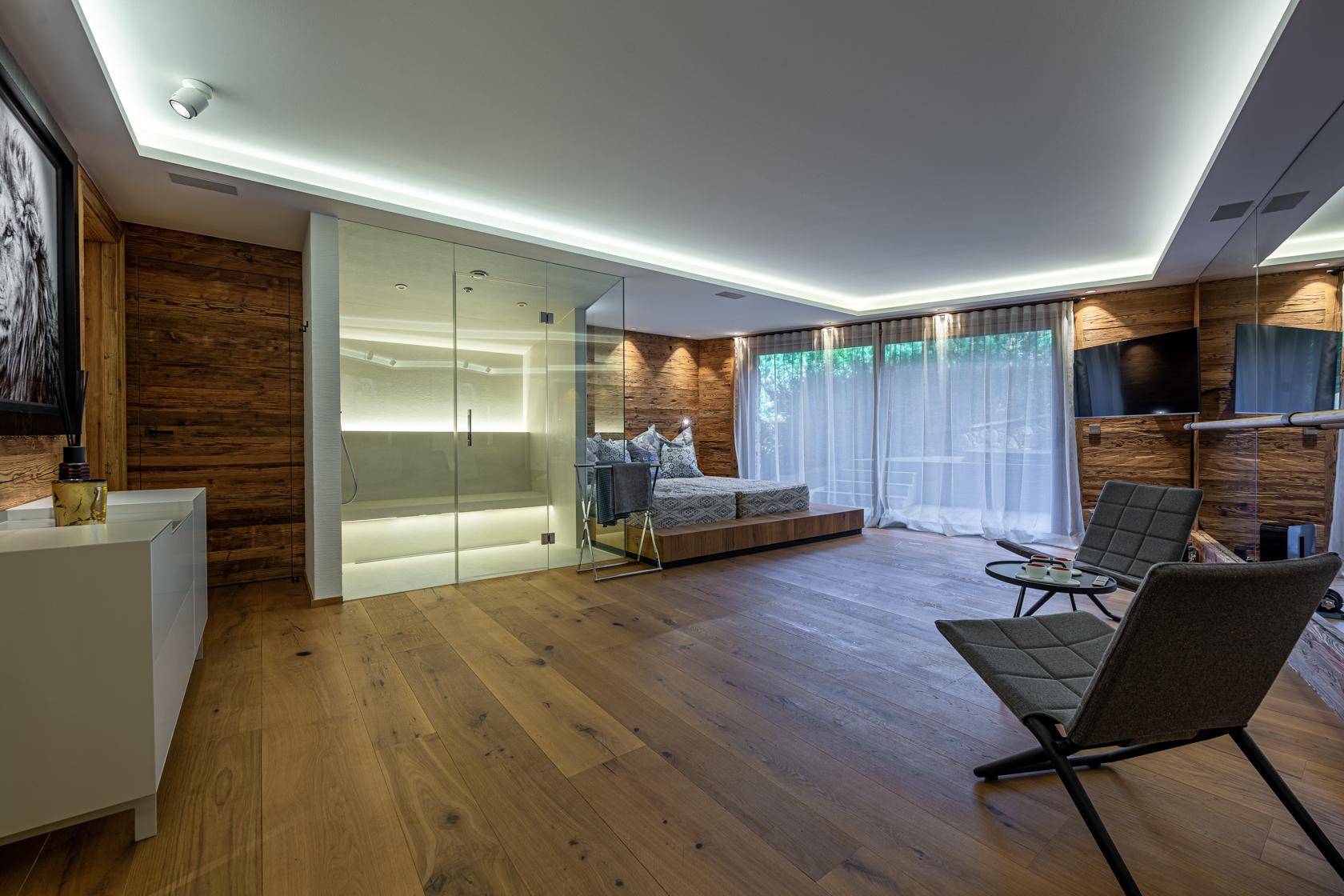 Geräumiges Schlafzimmer mit integriertem Wellnessbereich und Holzboden.