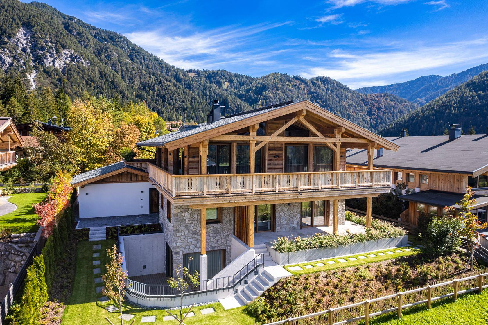 Luxuriöses Holzchalet in den Bergen mit gepflegtem Garten und weitem Blick auf die Landschaft.