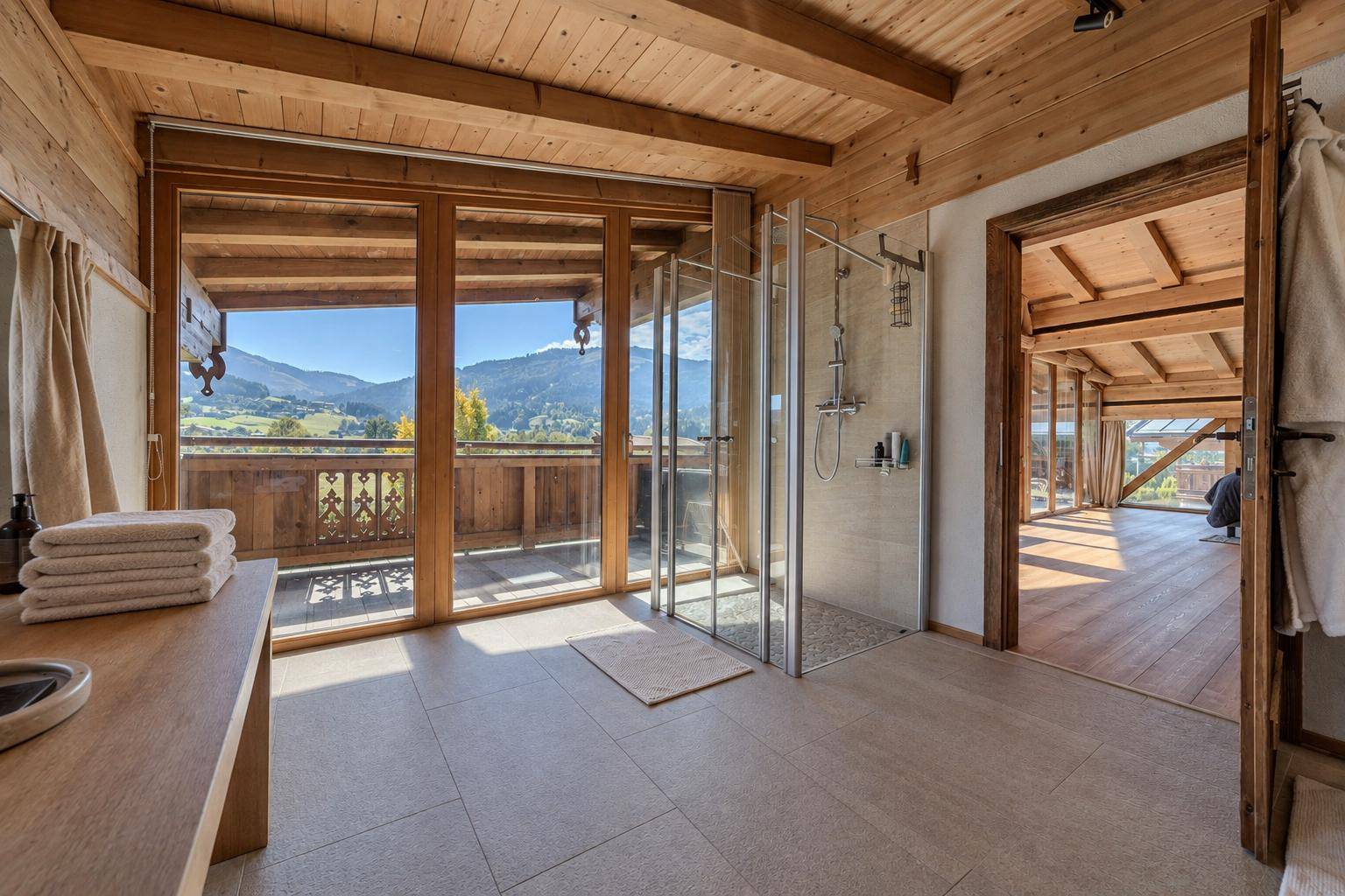 Modernes Badezimmer mit begehbarer Dusche, Fliesenboden und großem Fenster mit Bergblick.