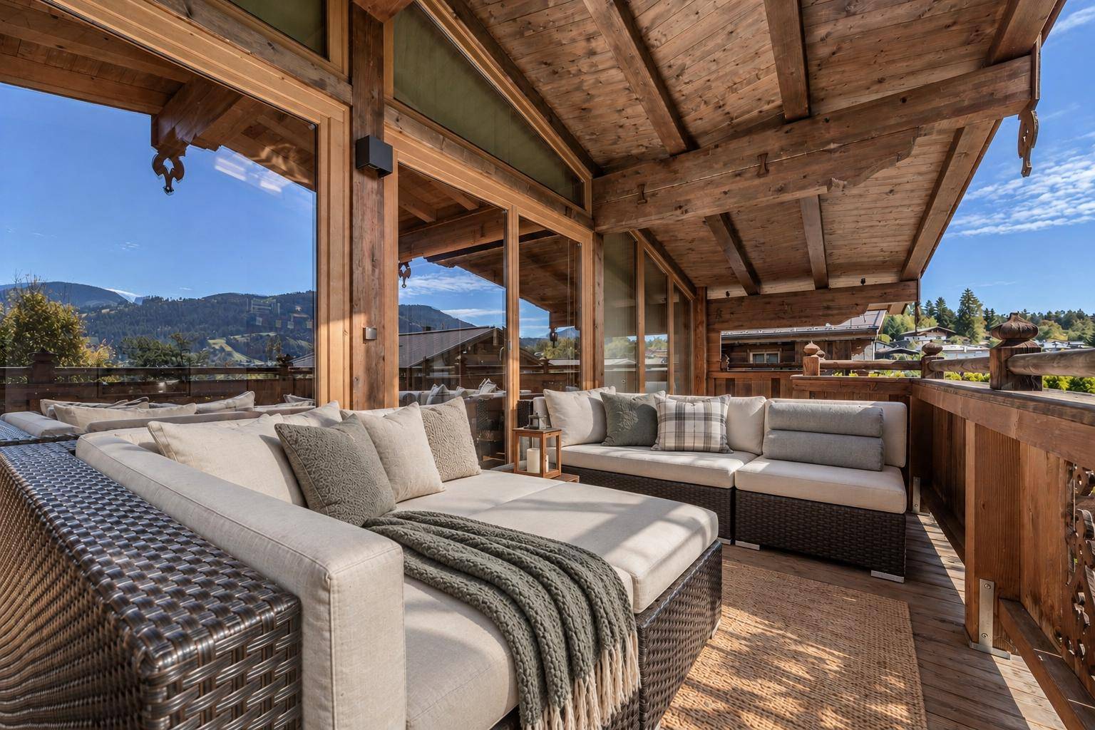 Geräumiger Balkon mit bequemen Loungemöbeln und weitem Blick auf die umliegende Berglandschaft.