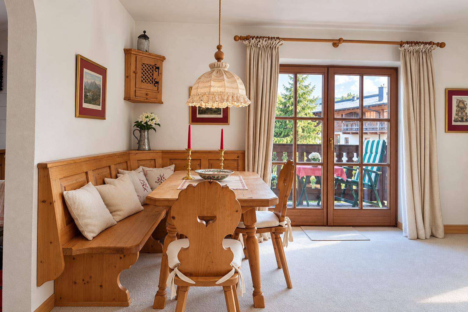 Rustikaler Essbereich mit Holzbänken, Esstisch und direktem Zugang zu einem sonnigen Balkon.