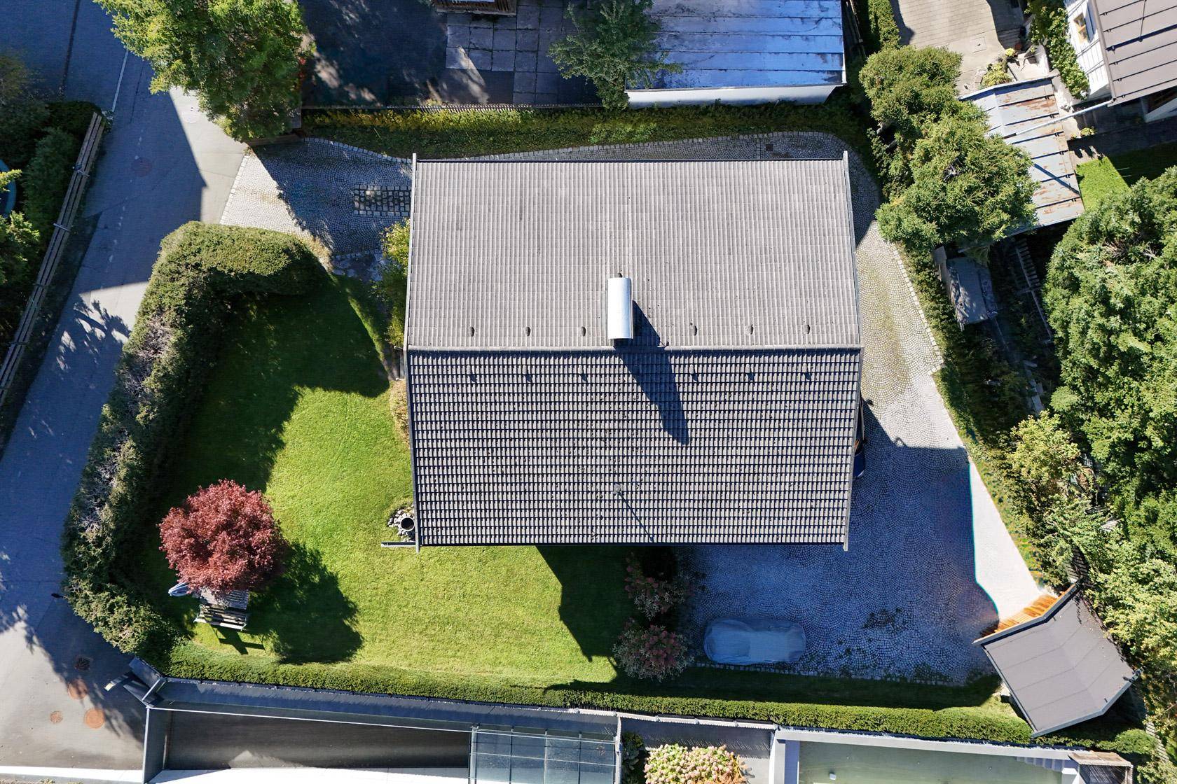 Luftaufnahme des Hauses mit Satteldach, gepflegtem Garten und Zufahrt von oben.