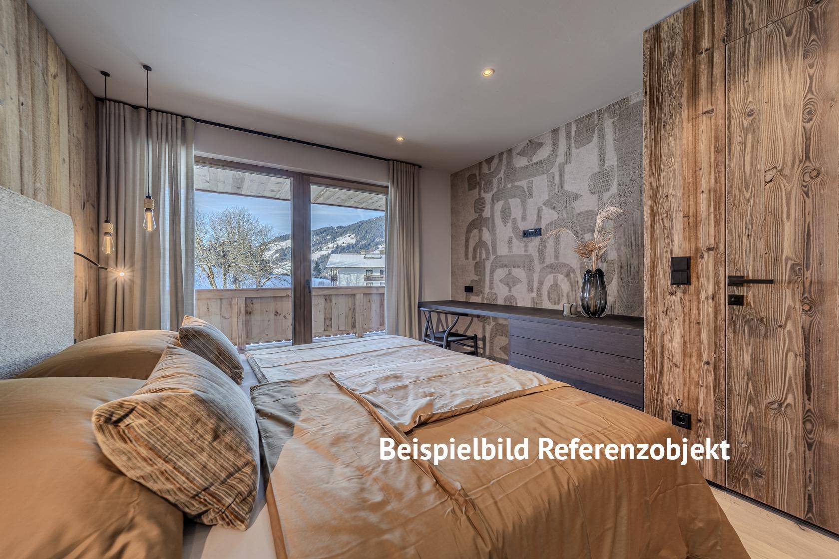 Schlafzimmer mit Holzwänden, Balkonzugang und Blick auf die verschneite Landschaft.