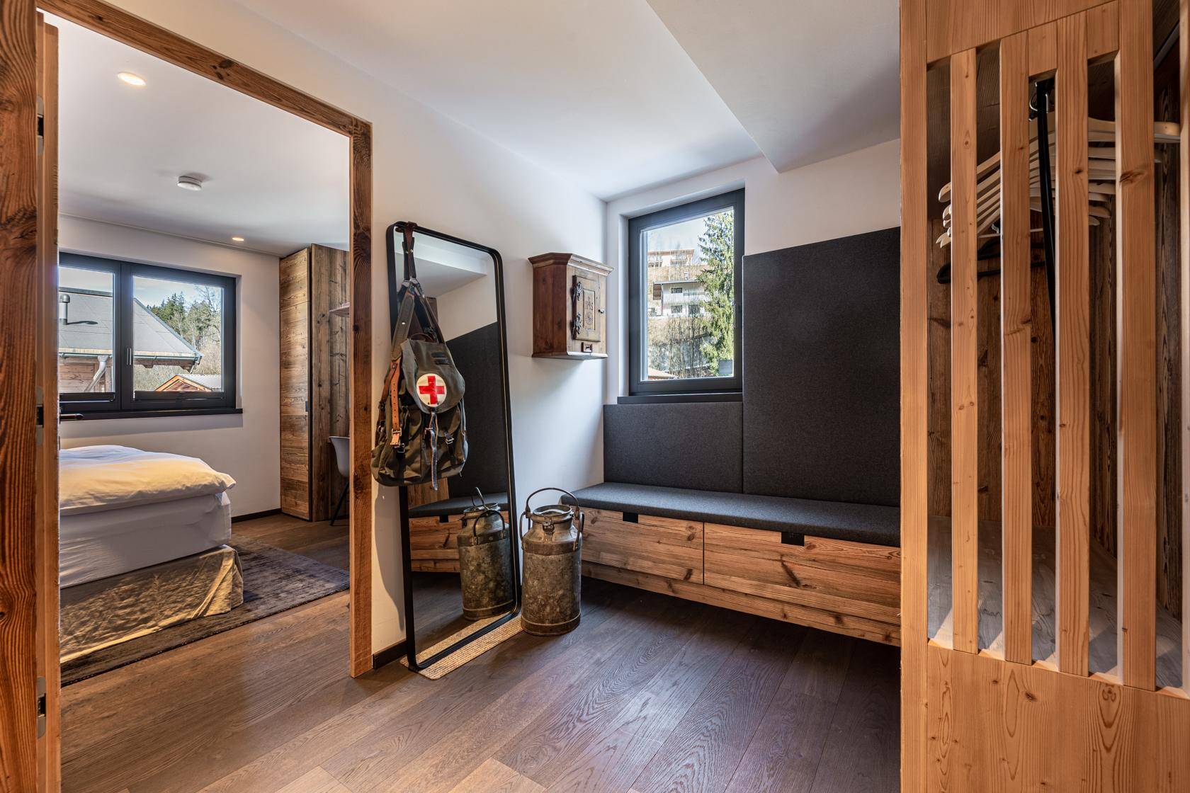 Eingangsbereich mit Holzboden, Sitzbank und Garderobe in rustikalem Stil.