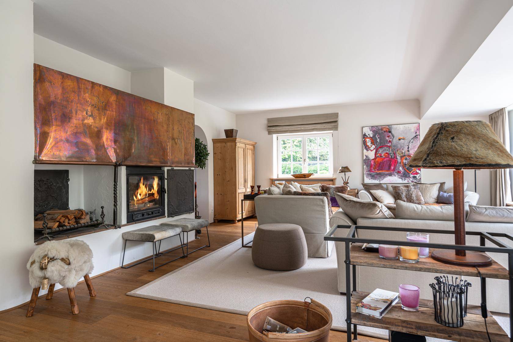 Helles Wohnzimmer mit modernem Kamin, bequemen Sofas und Holzboden.