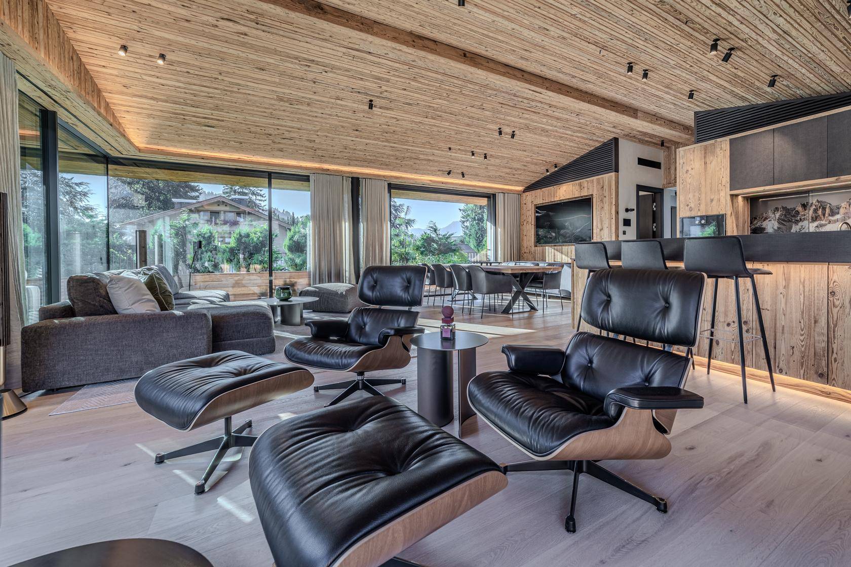 Elegantes Wohnzimmer mit Designer-Sesseln, bequemer Couch und integrierter Bar.