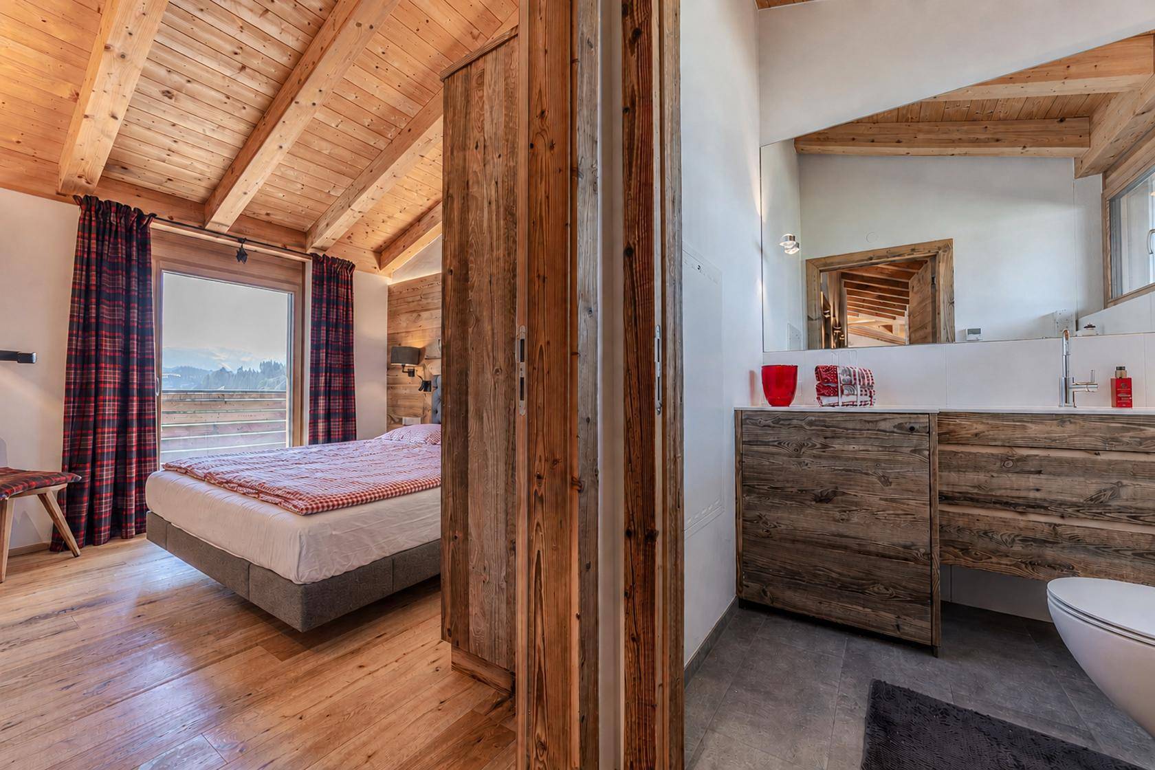 Helles Schlafzimmer mit Holzwänden und angrenzendem, modernem Badezimmerbereich.