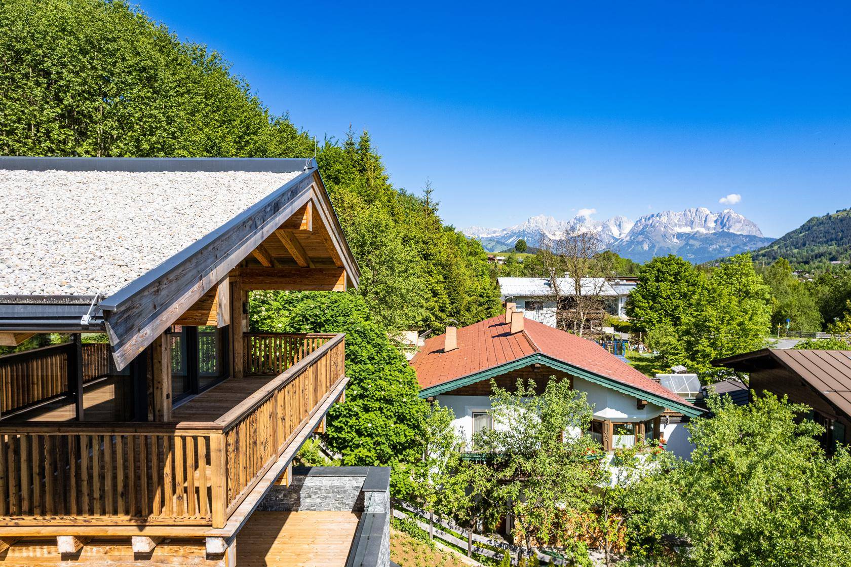 Malerischer Ausblick von der Terrasse auf die umliegende Berglandschaft und Nachbarhäuser.