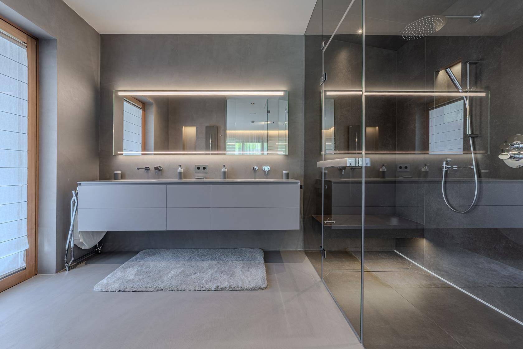 Modernes Badezimmer mit Doppelwaschbecken, großer begehbarer Dusche und grauen Fliesen.
