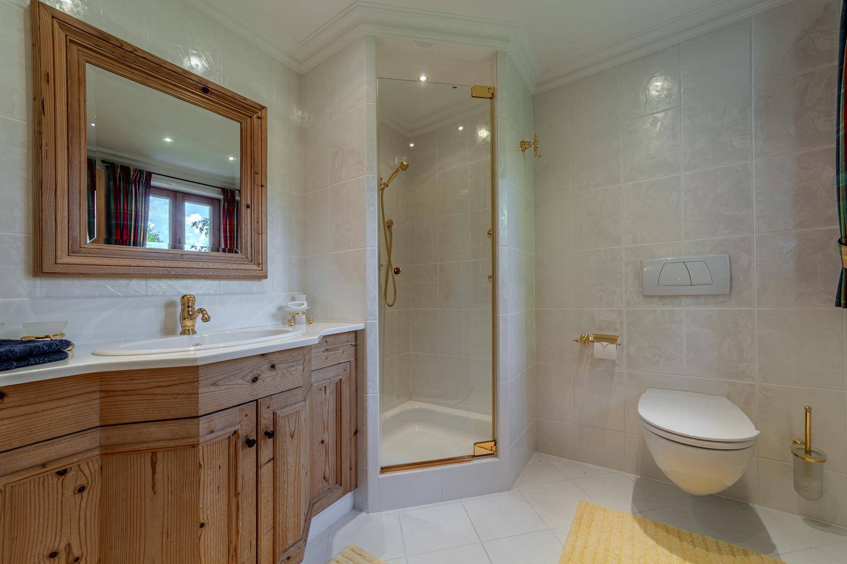 Modernes Badezimmer mit Duschkabine, Wand-WC und Holzwaschtisch im Landhausstil.