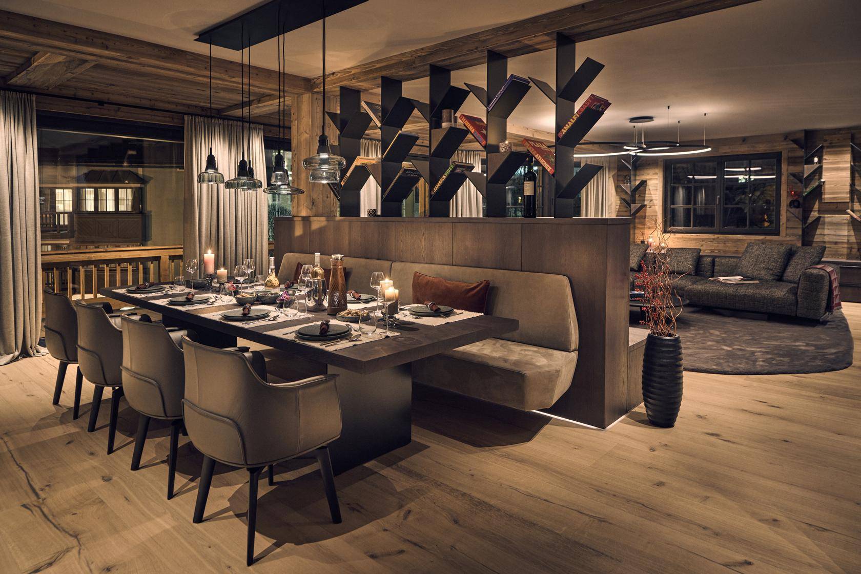 Eleganter Essbereich mit Holzbalken, langer Tafel und offener Verbindung zum Wohnzimmer.
