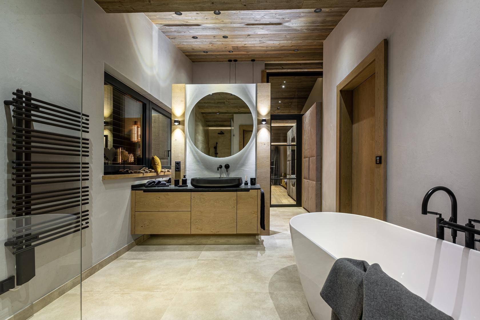 Modernes Badezimmer mit freistehender Badewanne, Doppelwaschbecken und beheiztem Handtuchhalter.