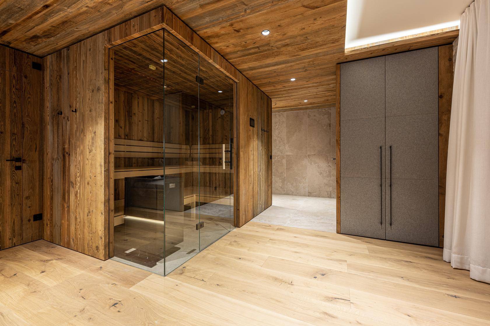 Elegante Sauna mit Glasfront in einem luxuriösen Wellnessbereich.