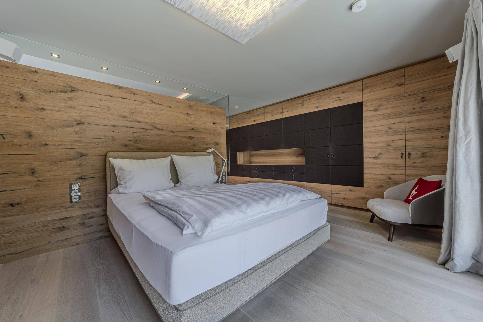 Modernes Schlafzimmer mit Holzwänden, integrierten Schränken und minimalistischem Design.