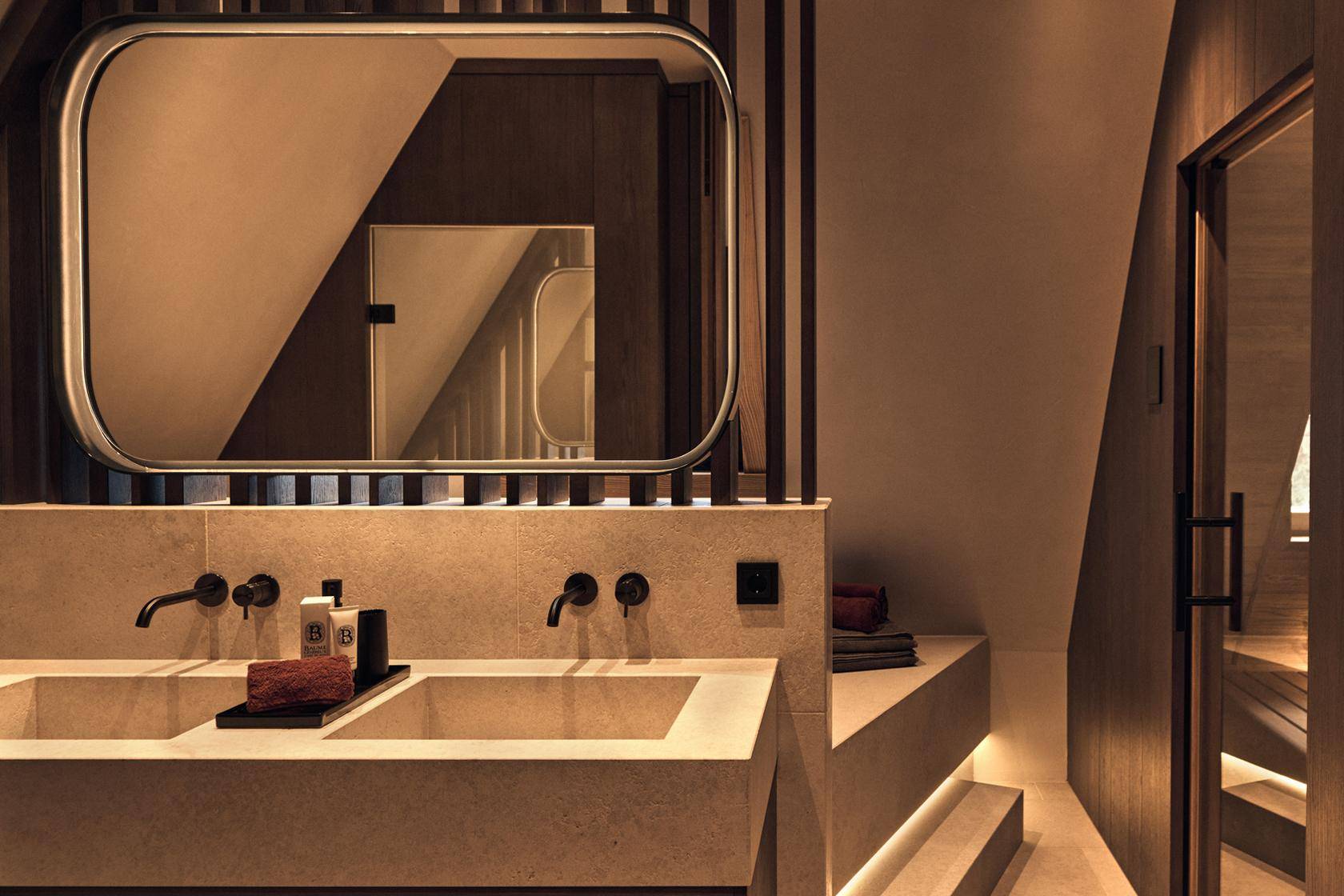 Modernes Badezimmer mit Doppelwaschbecken, indirekter Beleuchtung und stilvollem Spiegel.