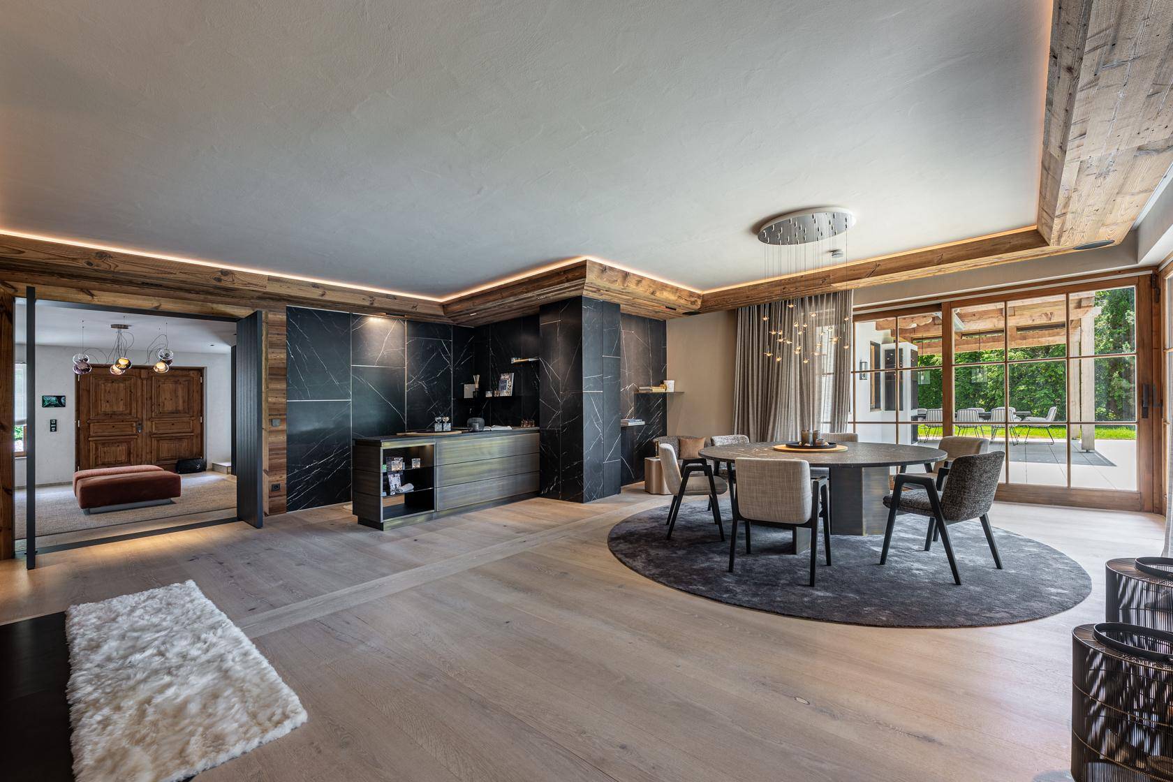 Eleganter Essbereich mit modernem Design, integrierter Bar und Zugang zu einer Außenterrasse.