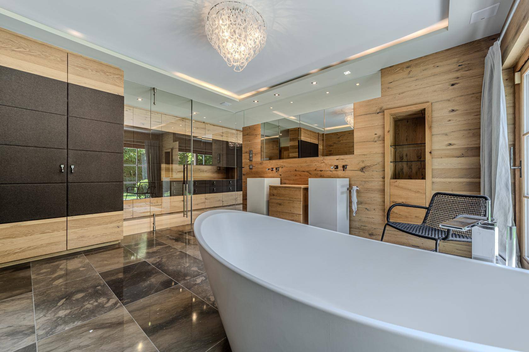 Luxuriöses Badezimmer mit freistehender Badewanne, Doppelwaschbecken und Holzvertäfelung.