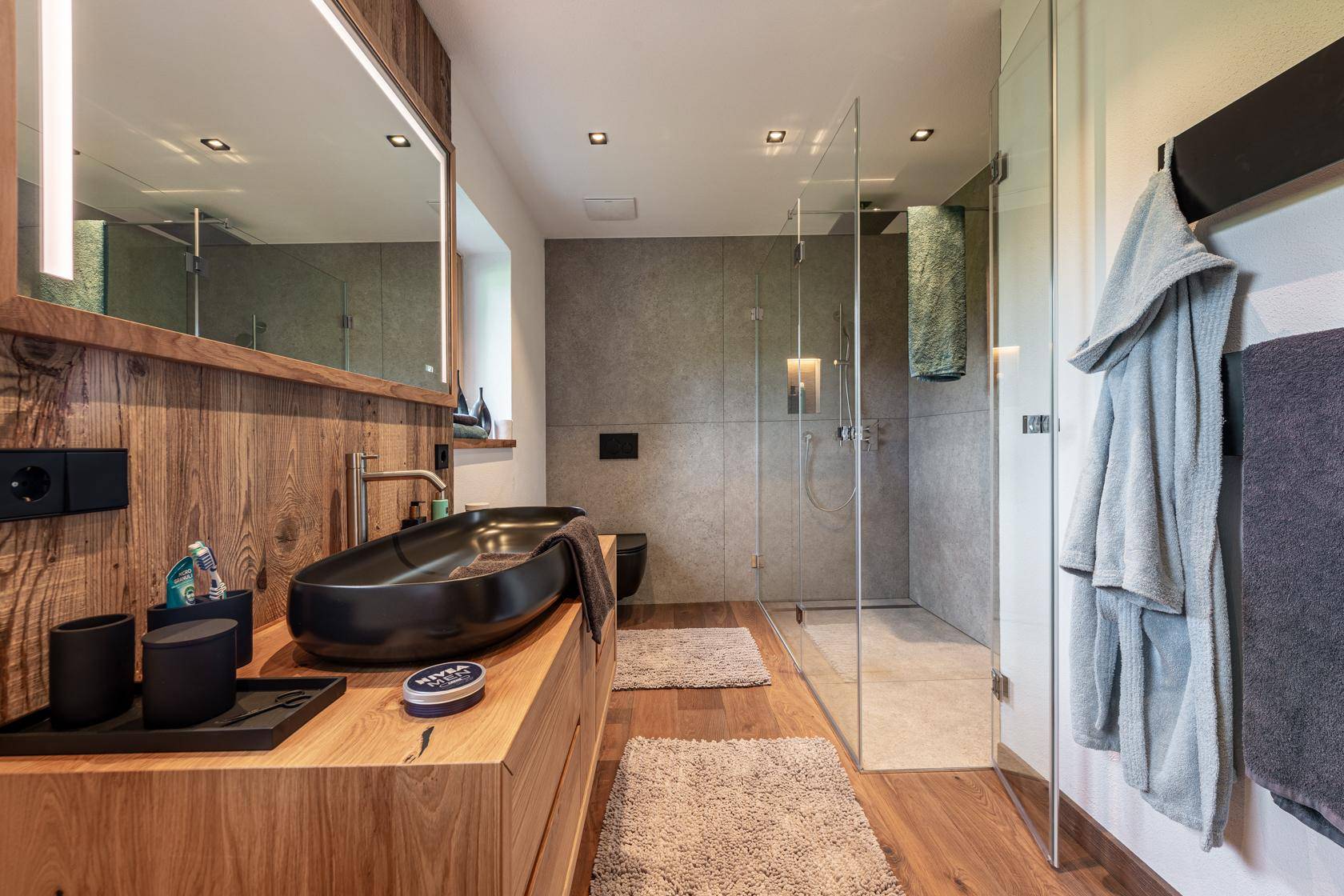 Geräumiges Badezimmer mit Doppelwaschbecken, großer Dusche und Holzdetails.