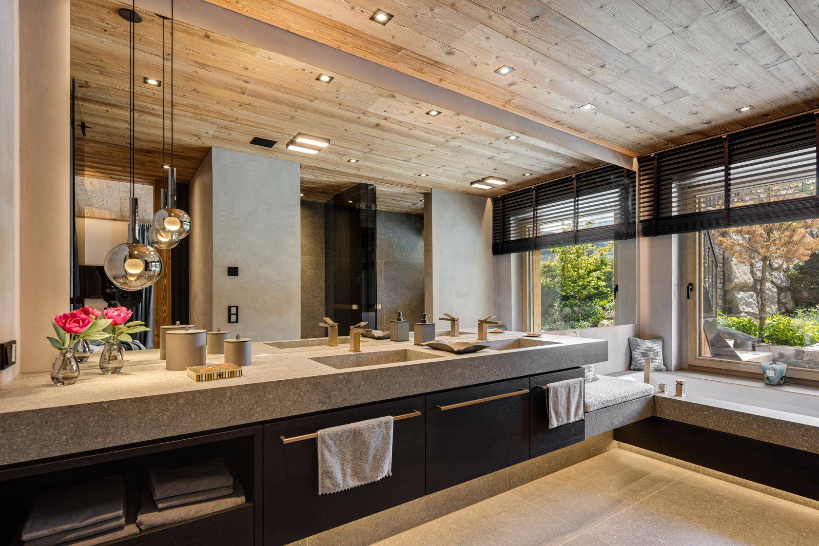 Modernes Badezimmer mit Doppelwaschbecken, Holzwänden und großem Fenster mit Blick ins Grüne.