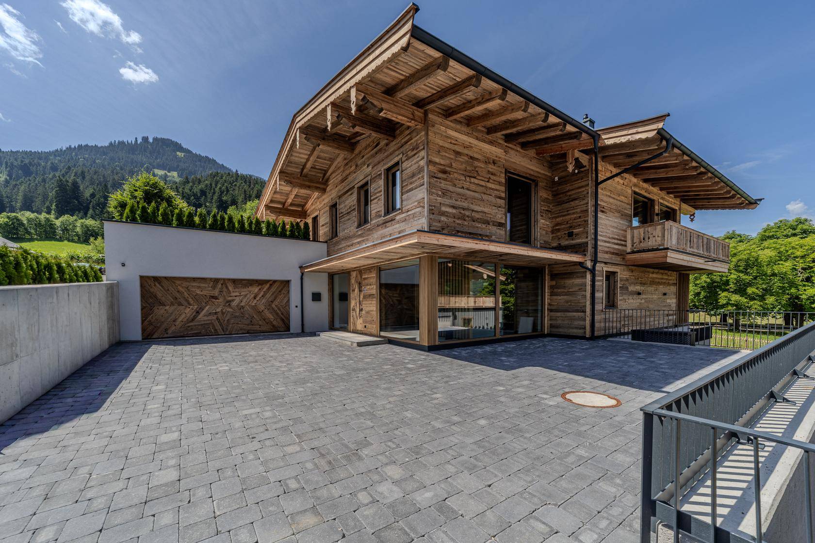 Elegantes Holzhaus mit moderner Architektur, großer Auffahrt und integrierter Garage.