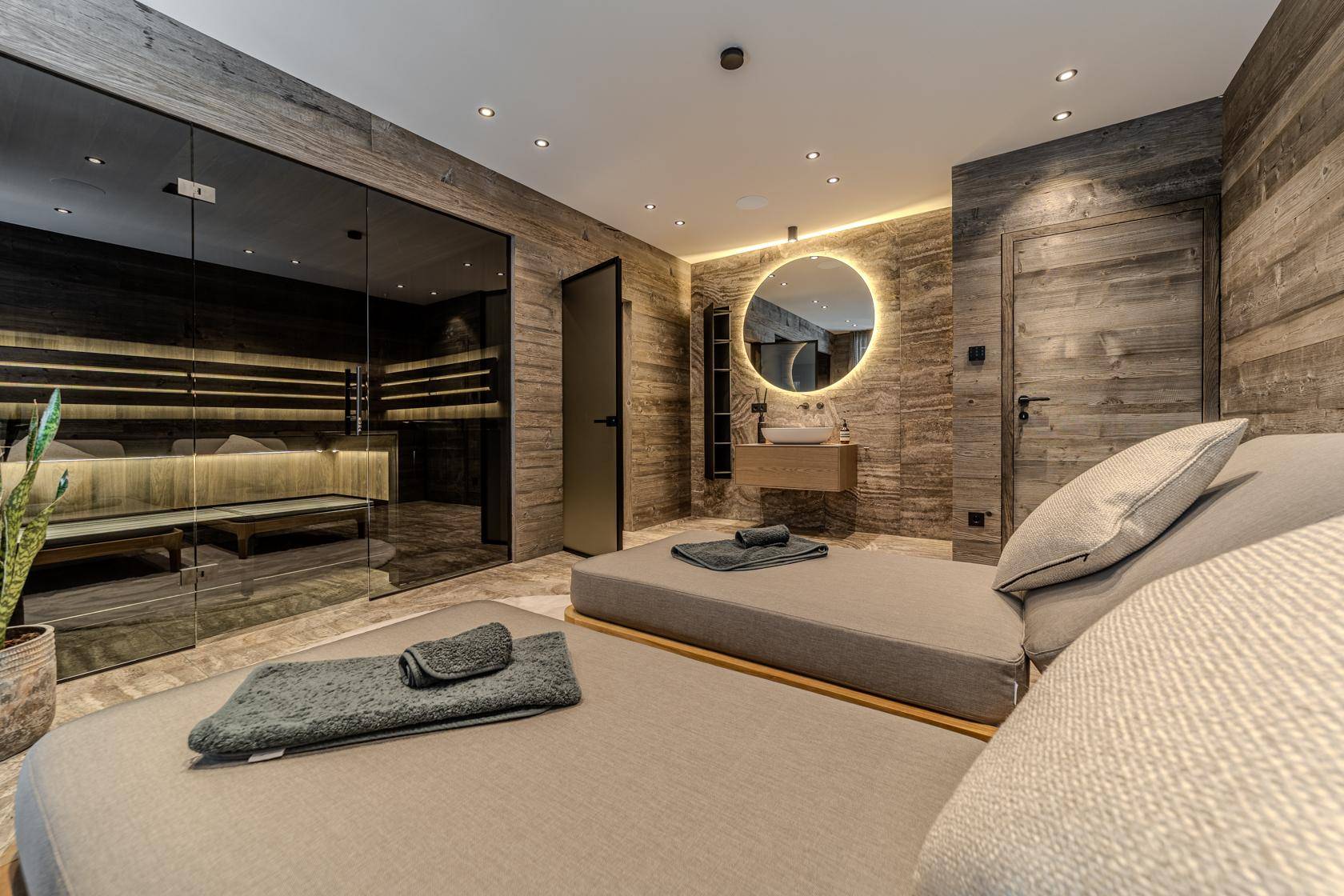 Moderner Wellnessbereich mit Sauna, Liegen und stilvoller Beleuchtung für Entspannung.