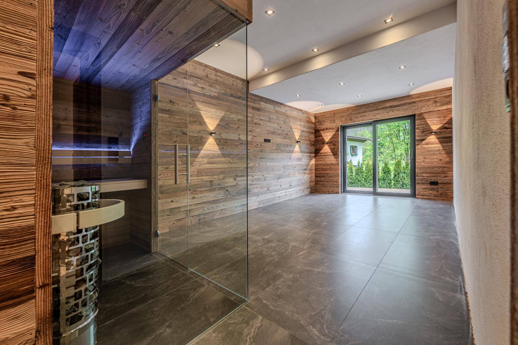 Moderner Wellnessbereich mit Sauna und Zugang zu einer Außenterrasse.
