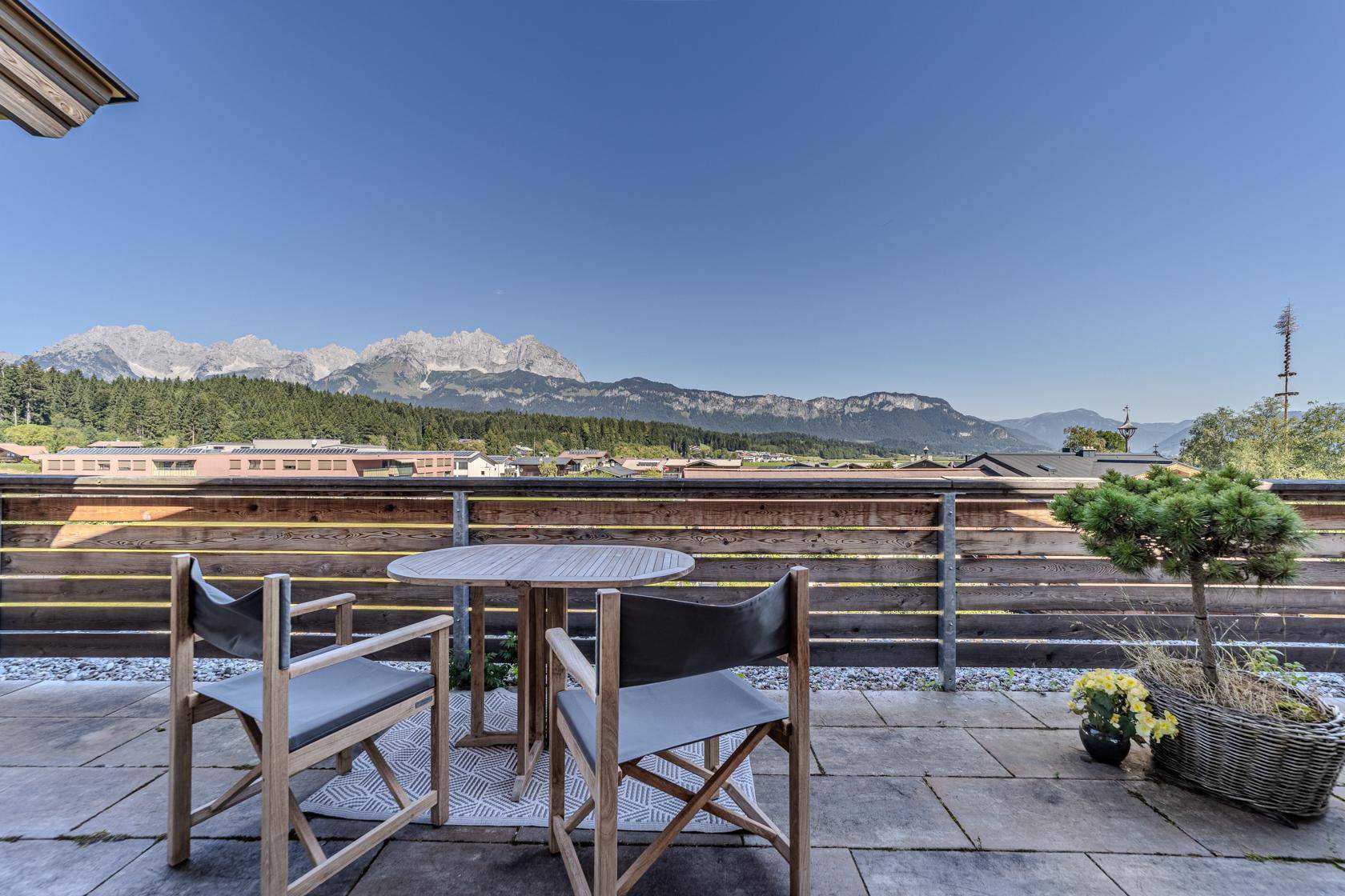 Sonnige Terrasse mit bequemen Sitzgelegenheiten und beeindruckendem Bergblick.