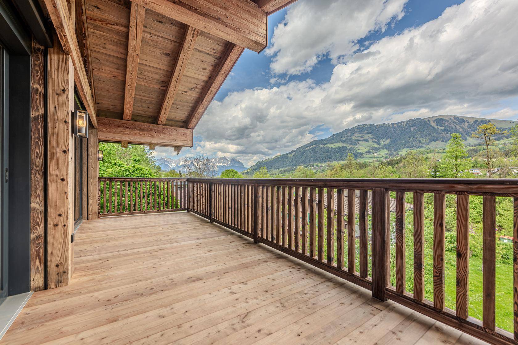 Geräumiger Holzbalkon mit Bergblick und viel Platz zum Entspannen.