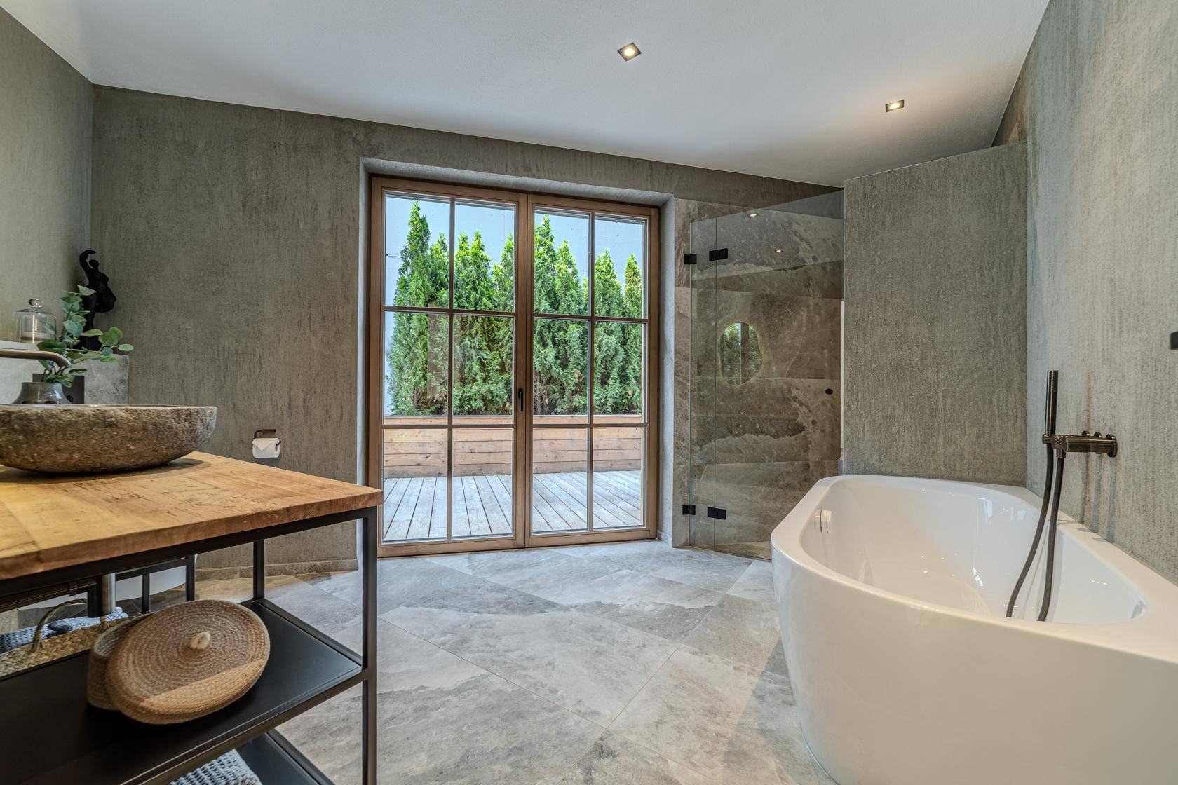 Elegantes Badezimmer mit freistehender Badewanne, begehbarer Dusche und großen Fenstern.