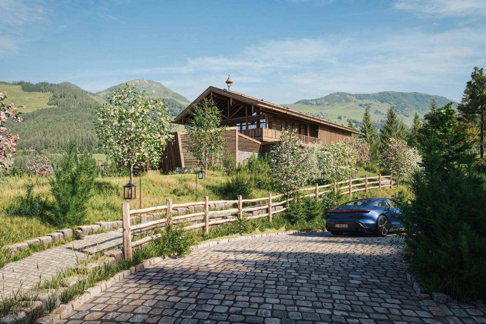Zufahrt zum luxuriösen Chalet mit Kopfsteinpflaster und rustikalem Holzzaun in alpiner Landschaft.