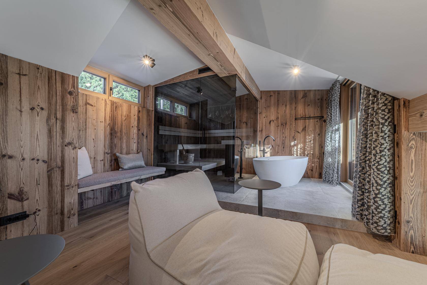 Luxuriöses Badezimmer mit Sauna, freistehender Badewanne und Holzwänden für Wellness.