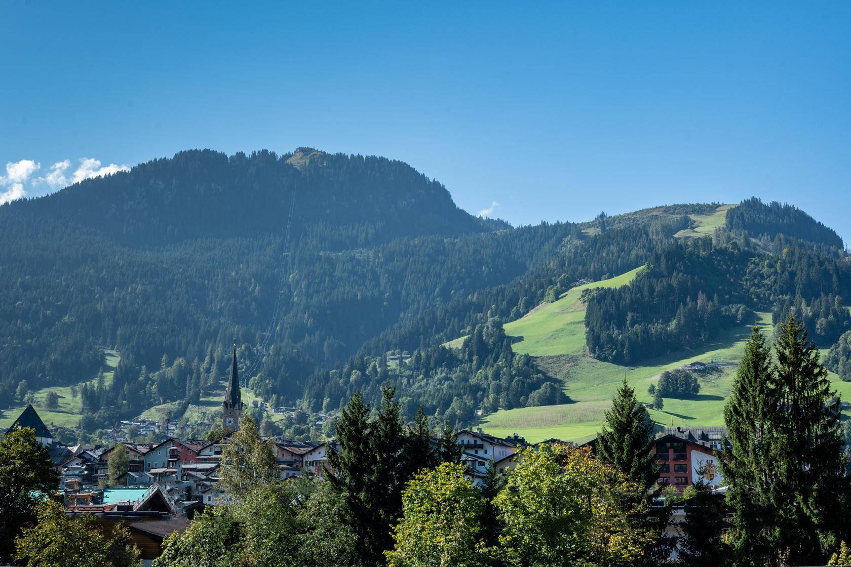 Panoramablick auf eine malerische Berglandschaft mit einem Dorf im Tal.