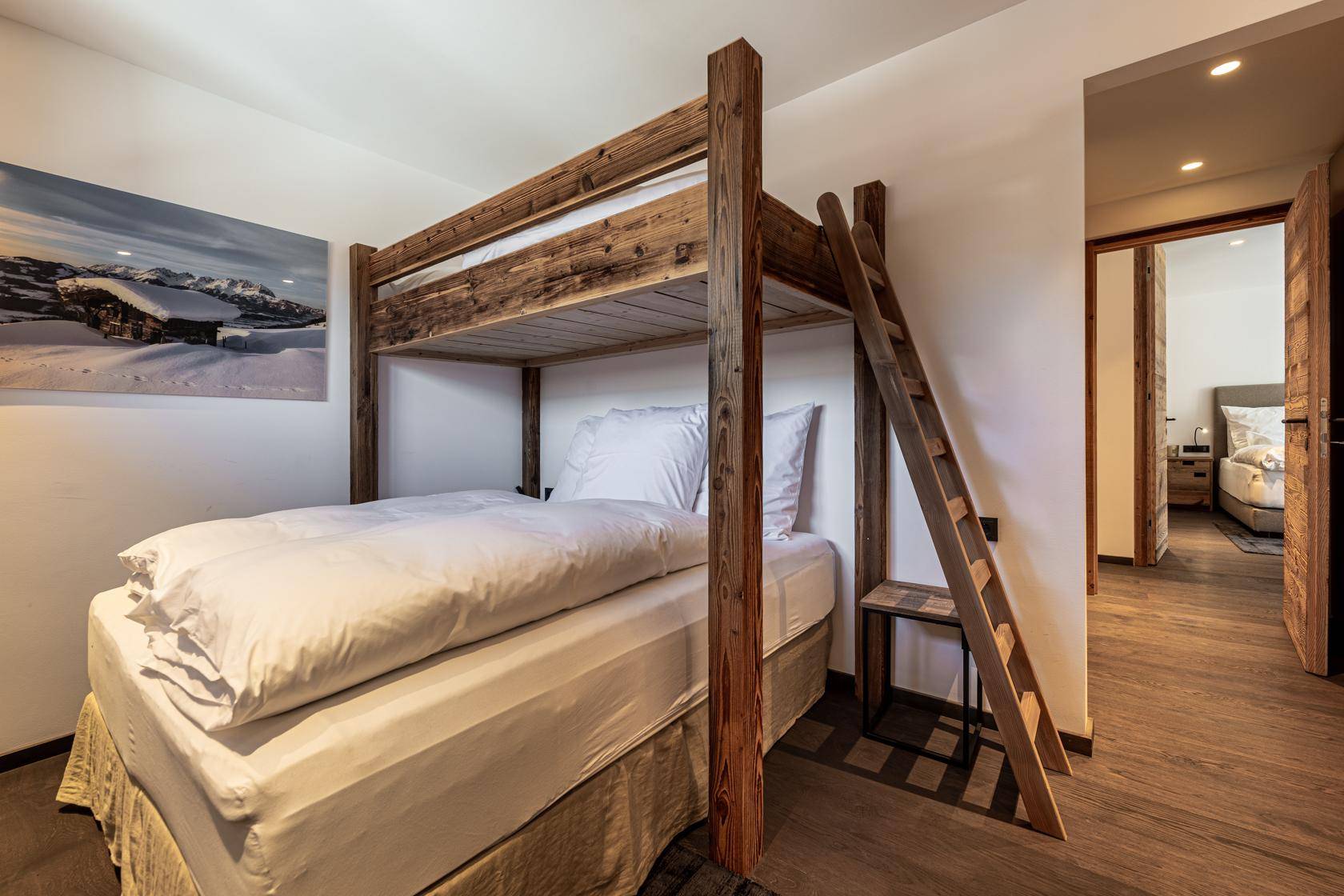 Kinderzimmer mit rustikalem Holz-Etagenbett und Holzboden, ideal für Gäste.