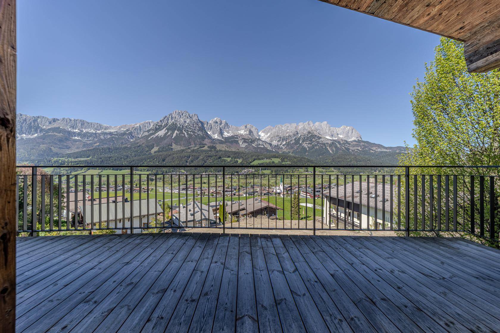 Geräumiger Holzbalkon mit atemberaubendem Blick auf die umliegende Berglandschaft.