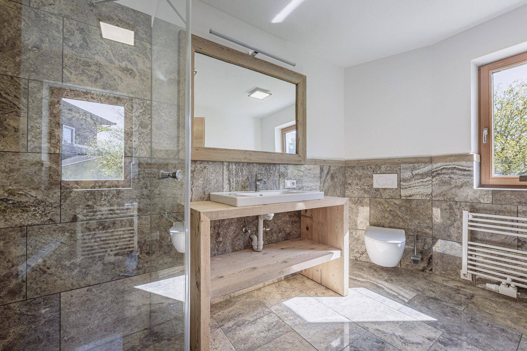 Modernes Badezimmer mit ebenerdiger Dusche, Waschtisch und Fenster.